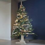Grand sapin de Noël design en bois naturel de 2 mètres de haut, branches rotatives artisanales sur socle stable.