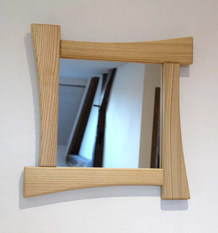 Miroir carré avec cadre en bois de frêne massif au design asymétrique et contemporain.